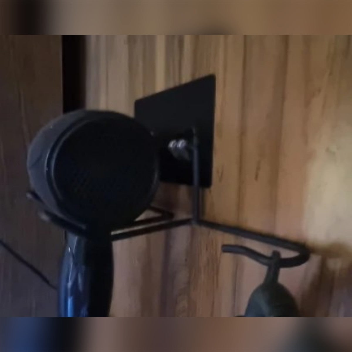Foto di un cliente: il porta phon nero su una parete in legno con l'asciugacapelli appoggiato