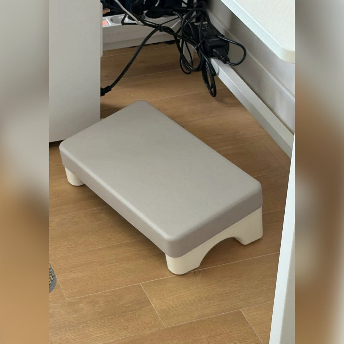 Foto di un cliente: il poggiapiedi grigio sul parquet, sotto la scrivania