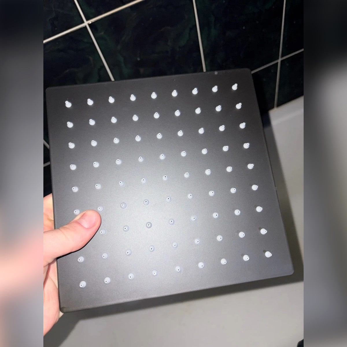Foto di un cliente: soffione quadrato nero da 20 cm in mano in bagno, con gli ugelli bianchi in vista