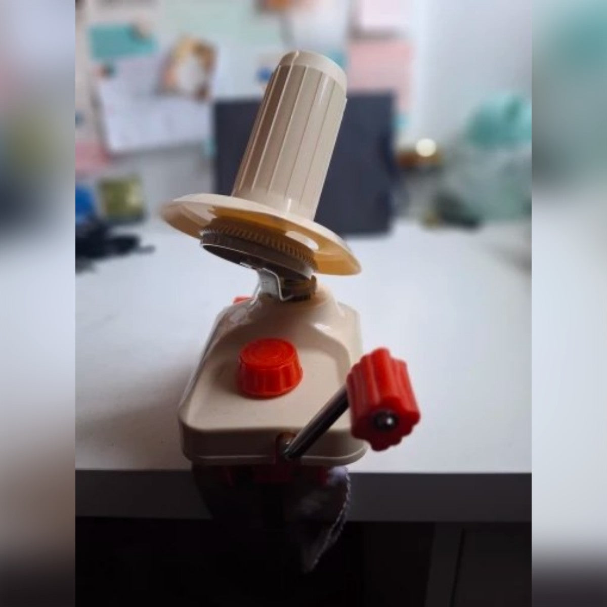 Foto di un cliente: il gomitolatore crema e rosso fissato al bordo di un tavolo