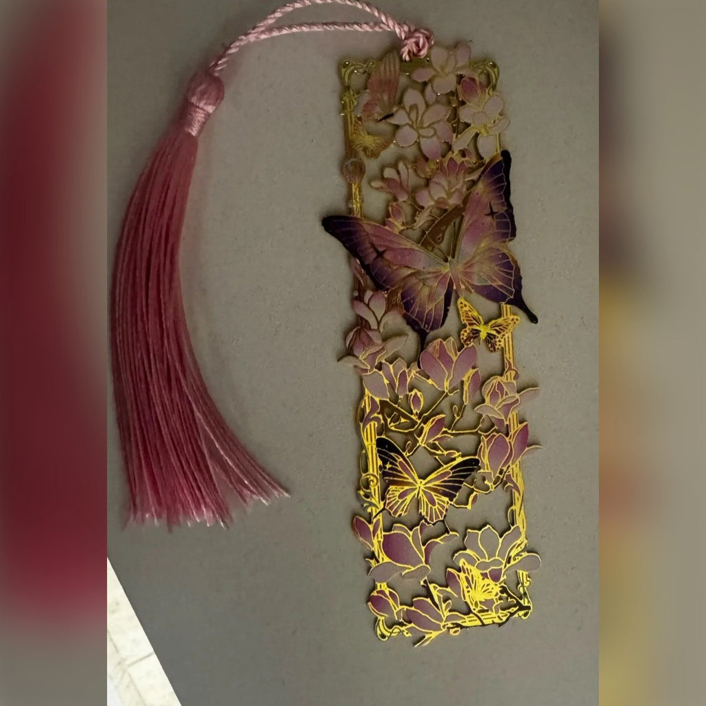 Il segnalibro in metallo traforato e la sua nappina su un tavolo (foto di un cliente)