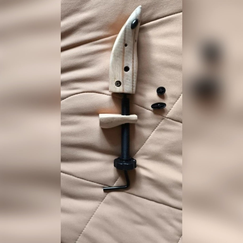 Foto di un cliente: allarga scarpe taglia M appoggiato su una coperta, con vite, blocco del tallone e due tappi neri