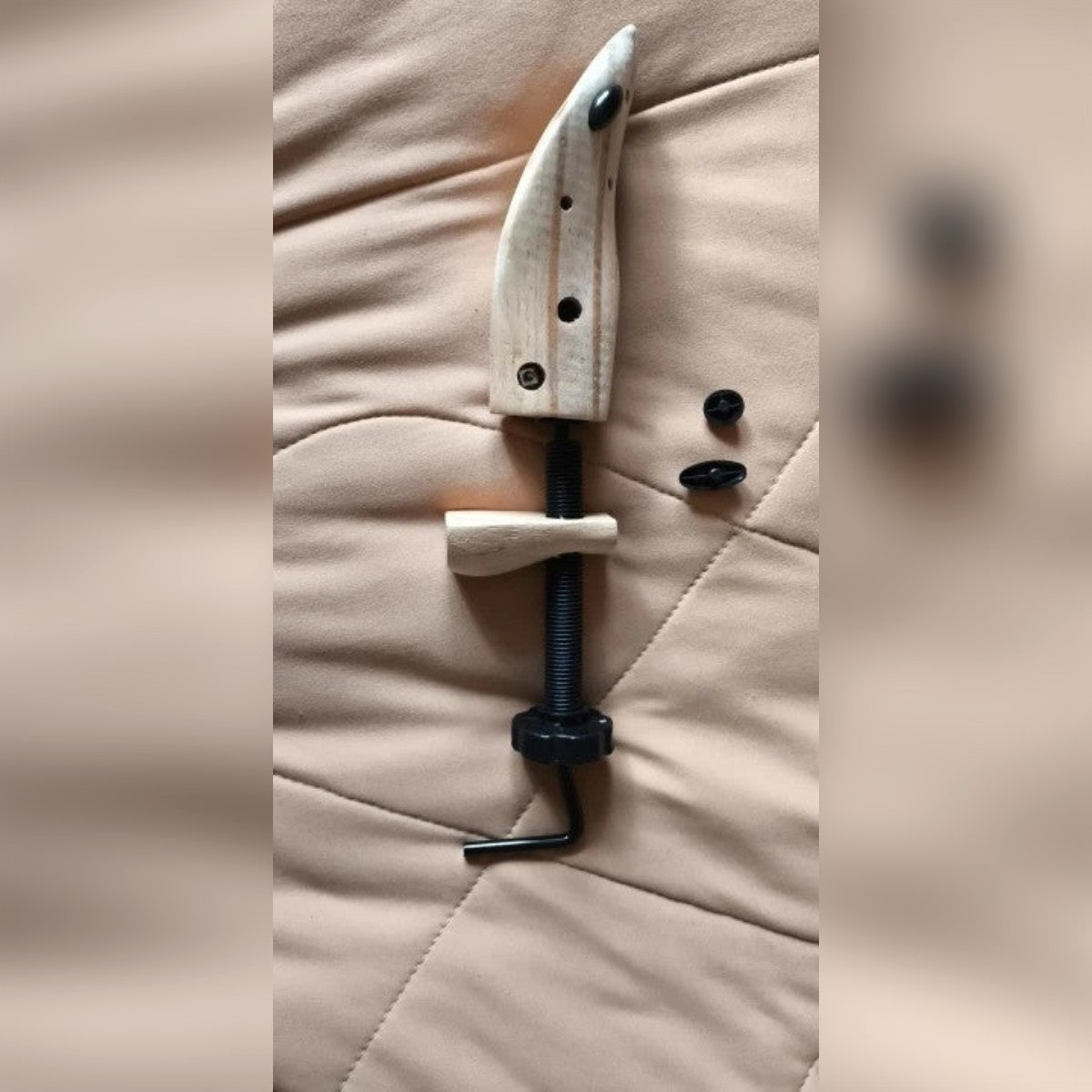 Foto di un cliente: allarga scarpe taglia M appoggiato su una coperta, con vite, blocco del tallone e due tappi neri