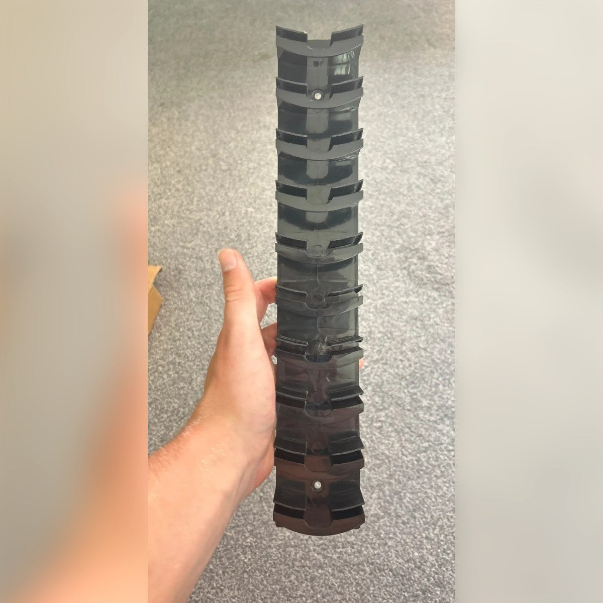 Foto di un cliente: porta cappelli nero tenuto in mano, con i ganci curvi uno sopra l'altro