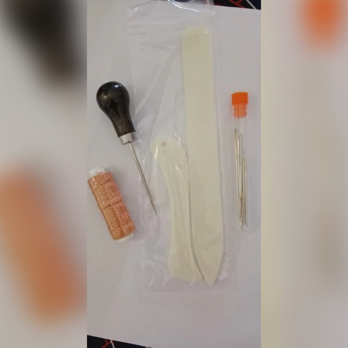 Foto di un cliente: il kit ricevuto, con le due stecche nella bustina, il punteruolo, il rocchetto di filo e gli aghi nel tubetto