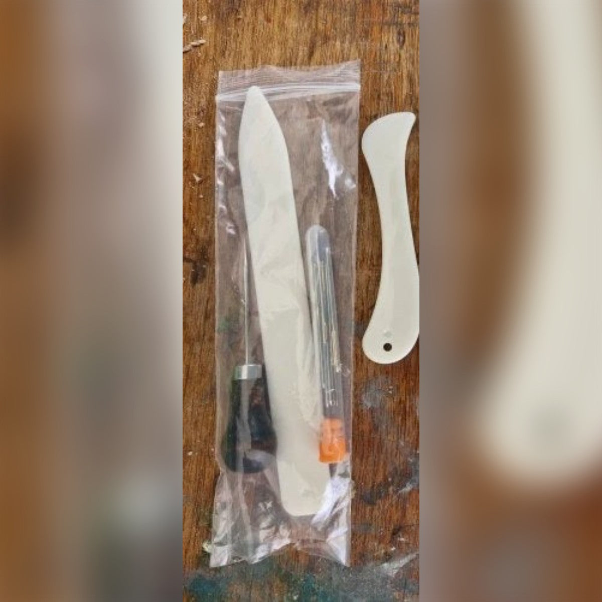 Foto di un cliente: la bustina con stecca lunga, punteruolo e aghi, e accanto la stecca curva