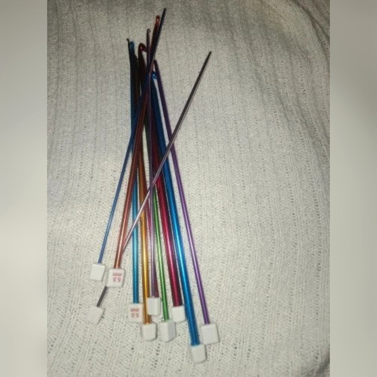 Foto di un cliente: il set completo su un tessuto a maglia chiaro, con i fermi bianchi in basso