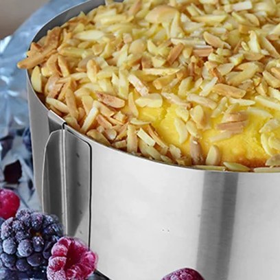 Torta con mandorle a lamelle dentro un anello per torte in acciaio inox