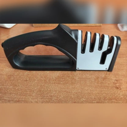 Foto di un acquirente: l'affilacoltelli ricevuto, visto dal lato dell'impugnatura, su un tavolo di legno