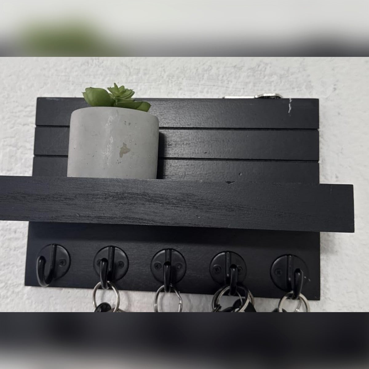 Foto di un acquirente: il porta chiavi nero con una piantina sulla mensola e le chiavi appese ai ganci