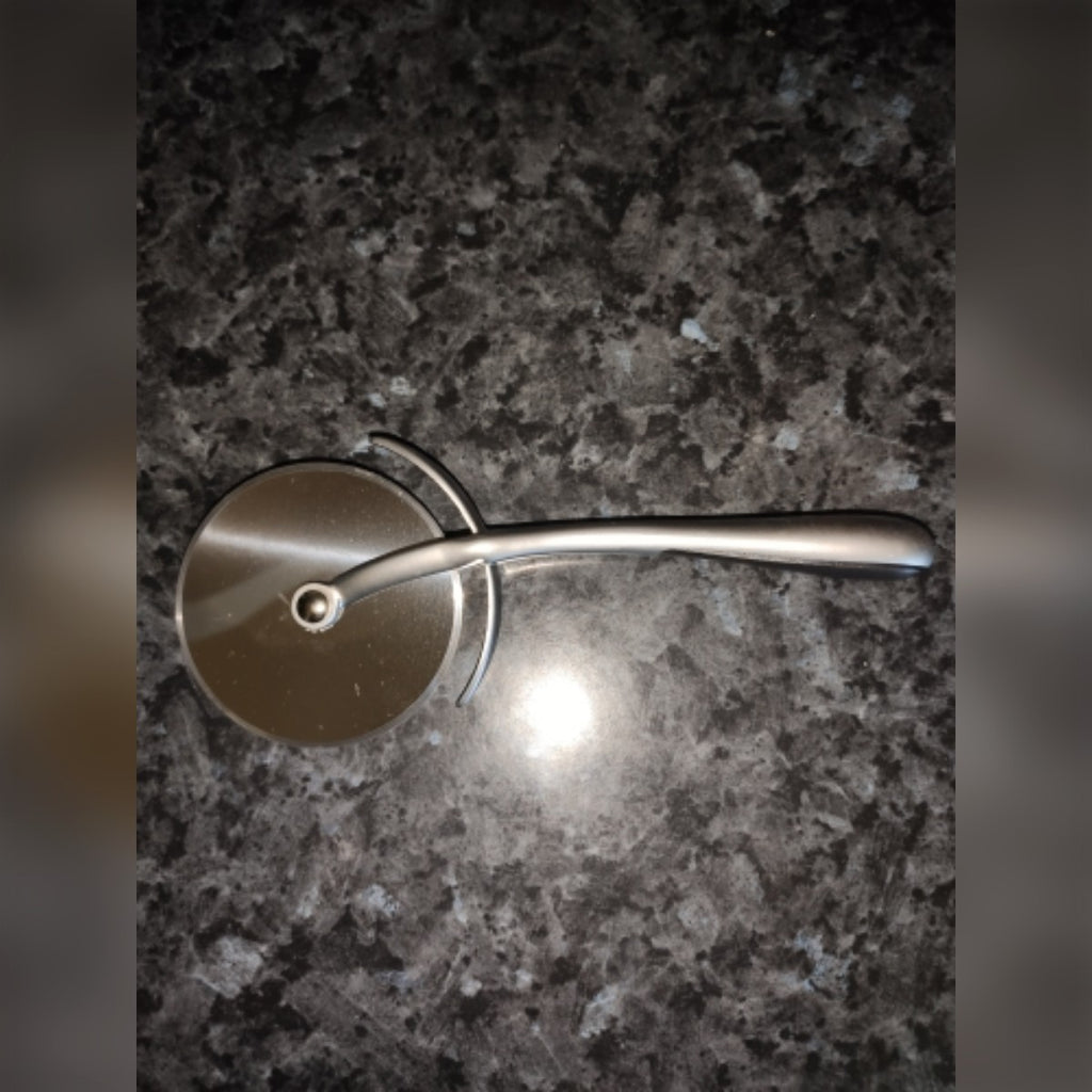 Foto di un acquirente: il tagliapizza su un piano di lavoro in granito