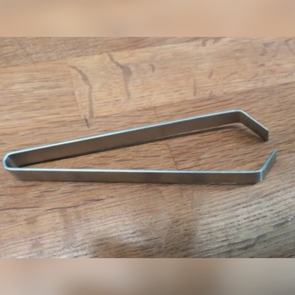 Foto di un acquirente: la pinzetta per pesce aperta su un tavolo di legno