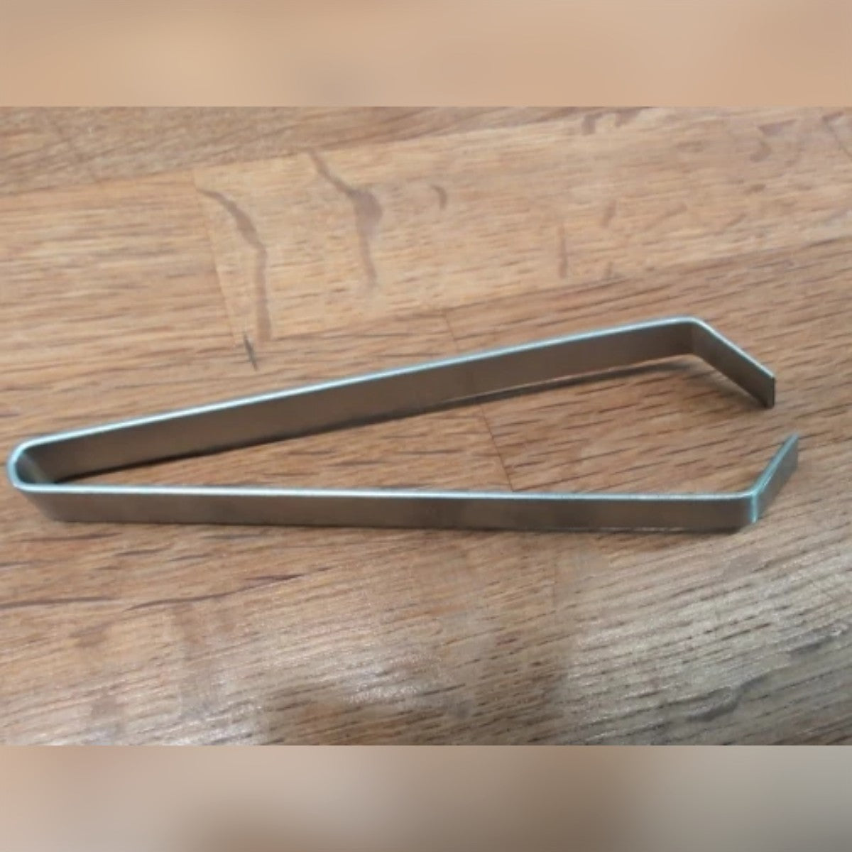 Foto di un acquirente: la pinzetta per pesce aperta su un tavolo di legno