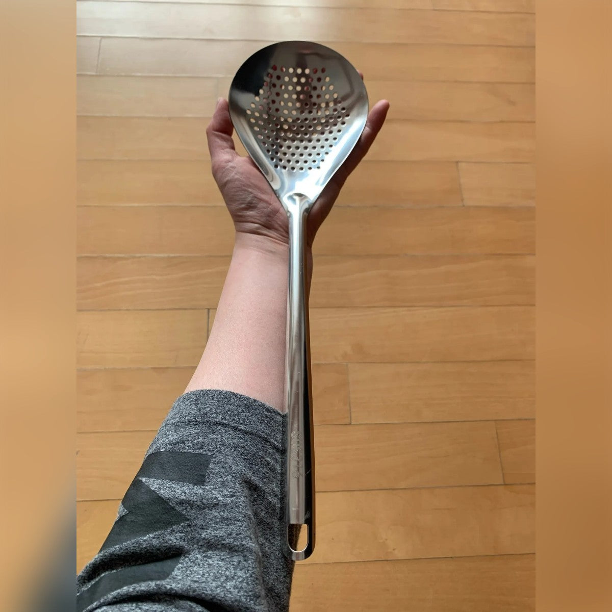 Foto di un acquirente: la schiumarola tenuta lungo l'avambraccio, per mostrarne la lunghezza