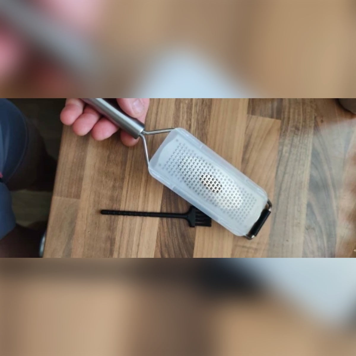 Foto di un acquirente: la grattugia con copri-lama e spazzolino su un tagliere