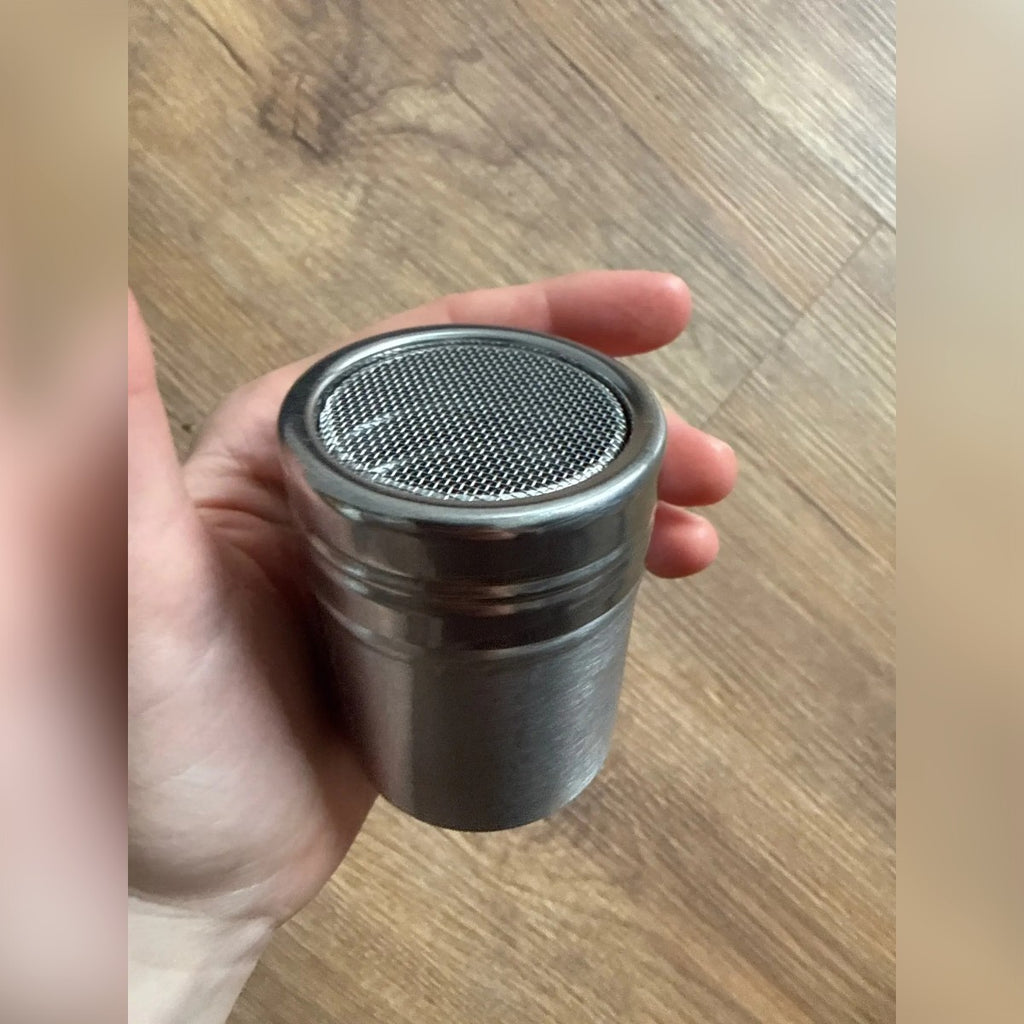 Foto di un acquirente: lo spargi zucchero in mano con la rete fine in alto