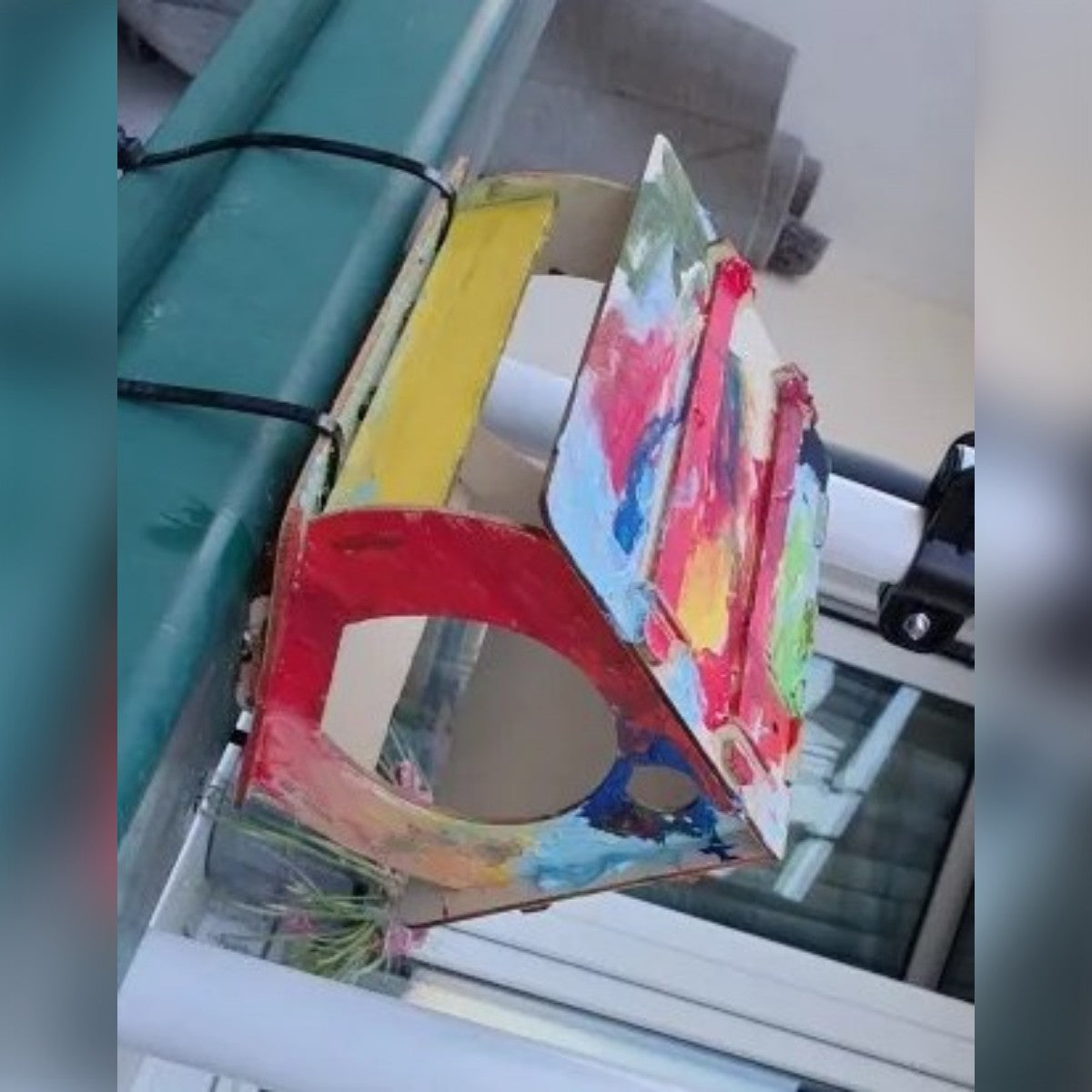 Foto di un acquirente: la stessa casetta dipinta dall'acquirente e legata alla ringhiera di un balcone