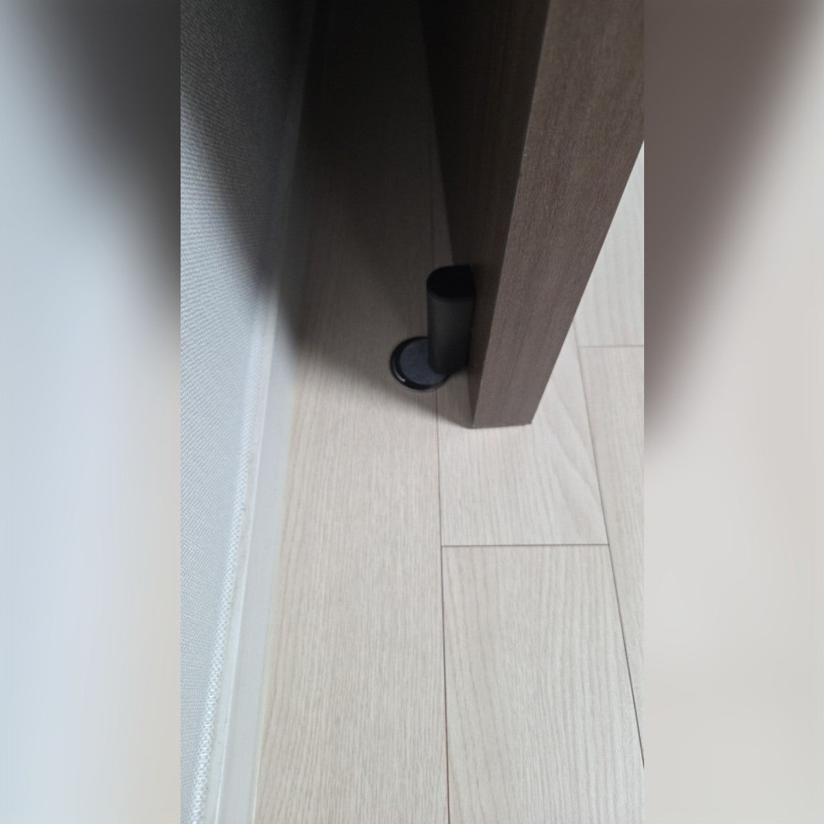 Foto di un acquirente: il fermaporta nero montato in basso su una porta marrone