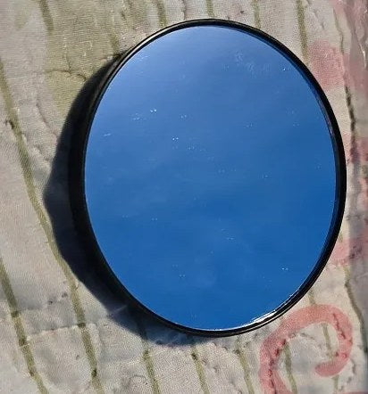 Foto di un acquirente: specchio ingranditore rotondo che riflette il cielo azzurro