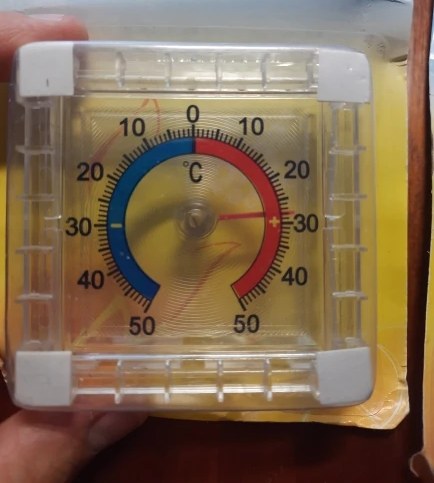 Foto di un acquirente: il termometro in mano, con la lancetta sopra zero