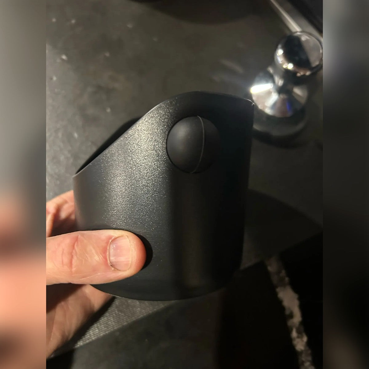 Foto di un cliente: il battifondi di lato in una mano, con l'estremità tonda della barra