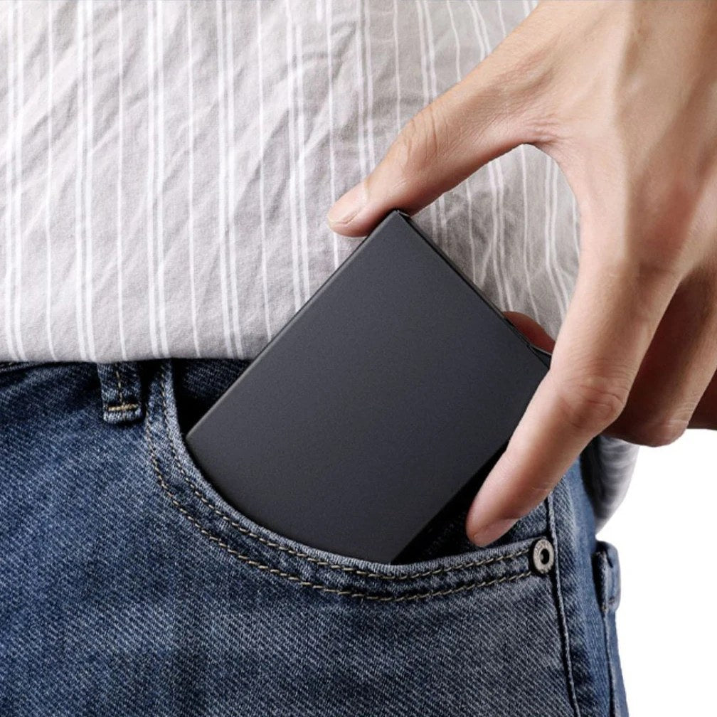 Portacarte nero infilato nella tasca davanti di un paio di jeans